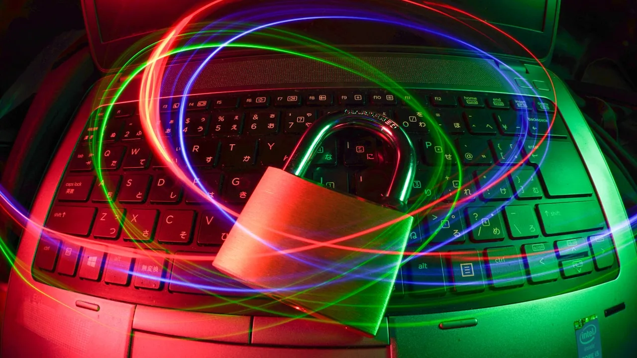 Padlock on laptop keyboard with colourful light trails